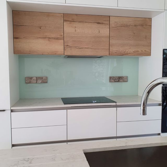 Pale blue glass splashback installed in a contemporary kitchen